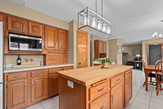 3226 W Twin Willow Ct, Appleton, WI 54914 - kitchen featuring stainless steel microwave, light tile patterned flooring, butcher block countertops, and brown cabinetry