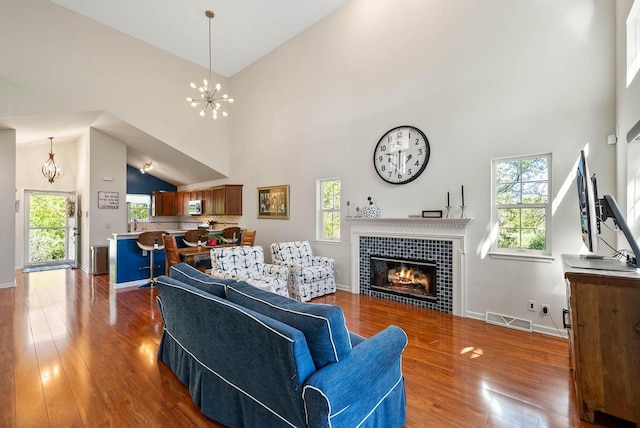 690 Valleyview Ct Unit 35-22, Lake Geneva, WI 53147 - living area with a chandelier, a high ceiling, hardwood / wood-style floors, a tiled fireplace, and baseboards