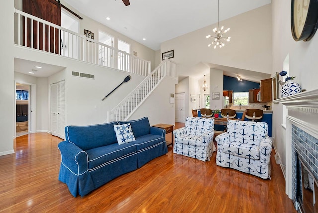 690 Valleyview Ct Unit 35-22, Lake Geneva, WI 53147 - living area featuring wood finished floors, a high ceiling, stairway, a tiled fireplace, and baseboards