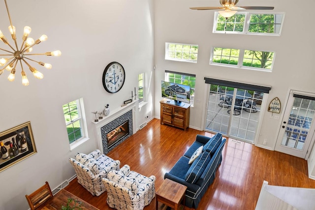 690 Valleyview Ct Unit 35-22, Lake Geneva, WI 53147 - living room featuring a tile fireplace, a towering ceiling, wood finished floors, and healthy amount of natural light