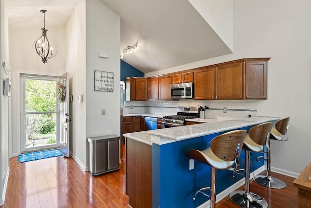 690 Valleyview Ct Unit 35-22, Lake Geneva, WI 53147 - kitchen featuring stainless steel appliances, decorative backsplash, wood finished floors, a peninsula, and baseboards