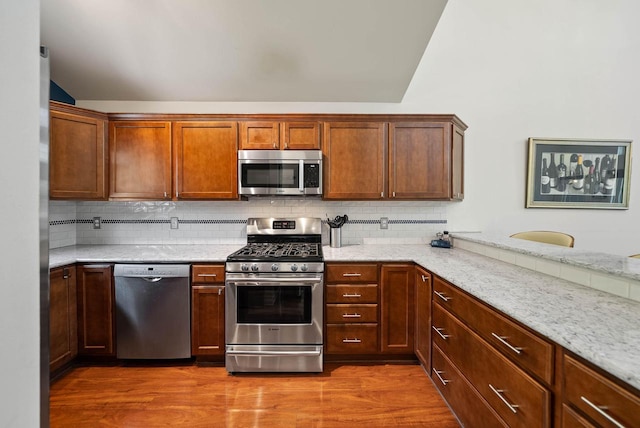 690 Valleyview Ct Unit 35-22, Lake Geneva, WI 53147 - kitchen featuring stainless steel appliances, backsplash, wood finished floors, and light stone counters