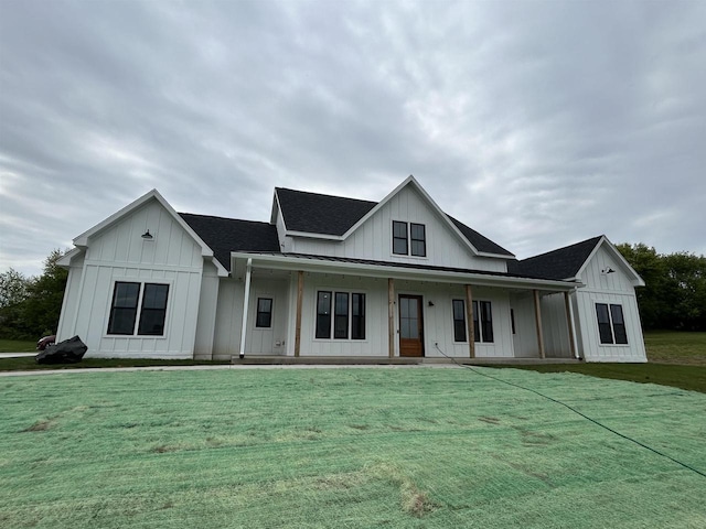 11654 Flambeau Rd, Tomah, WI 54660 - view of front of house with board and batten siding, a front lawn, covered porch, and a shingled roof