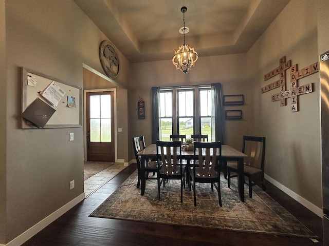 11654 Flambeau Rd, Tomah, WI 54660 - dining room featuring a chandelier, baseboards, and a raised ceiling