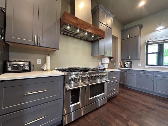 11654 Flambeau Rd, Tomah, WI 54660 - kitchen with range with two ovens, wall chimney range hood, gray cabinetry, and dark wood-style flooring