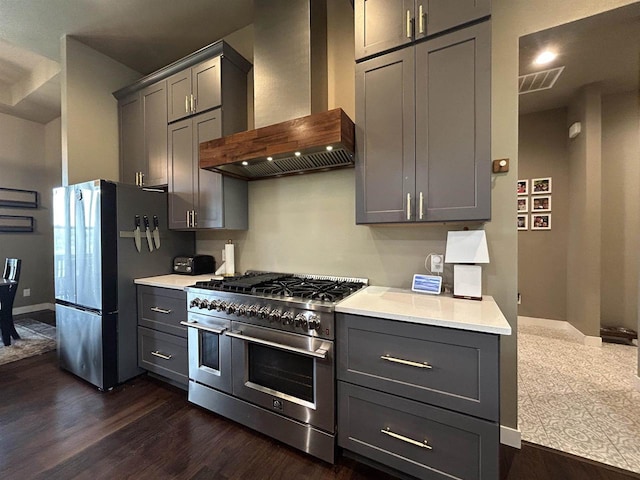 11654 Flambeau Rd, Tomah, WI 54660 - kitchen with wall chimney exhaust hood, appliances with stainless steel finishes, gray cabinetry, and dark wood-type flooring