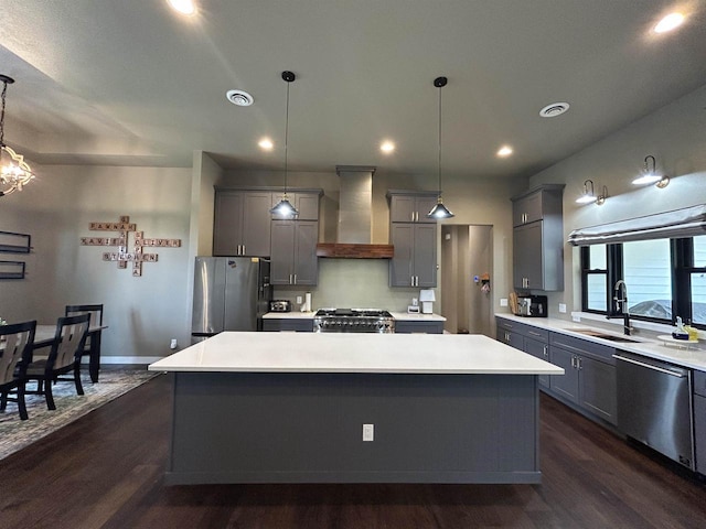 11654 Flambeau Rd, Tomah, WI 54660 - kitchen with wall chimney range hood, stainless steel appliances, a sink, gray cabinets, and a center island