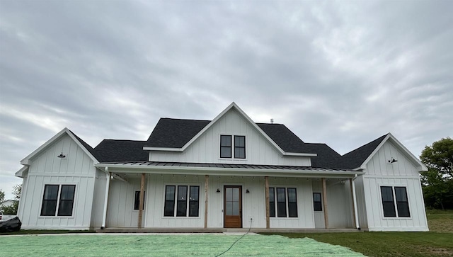11654 Flambeau Rd, Tomah, WI 54660 - view of front of house featuring a standing seam roof, board and batten siding, a porch, and a front yard