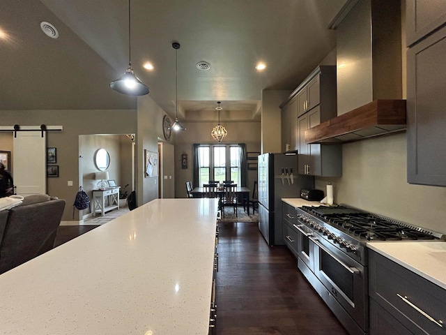 11654 Flambeau Rd, Tomah, WI 54660 - kitchen featuring wall chimney range hood, double oven range, a barn door, decorative light fixtures, and open floor plan