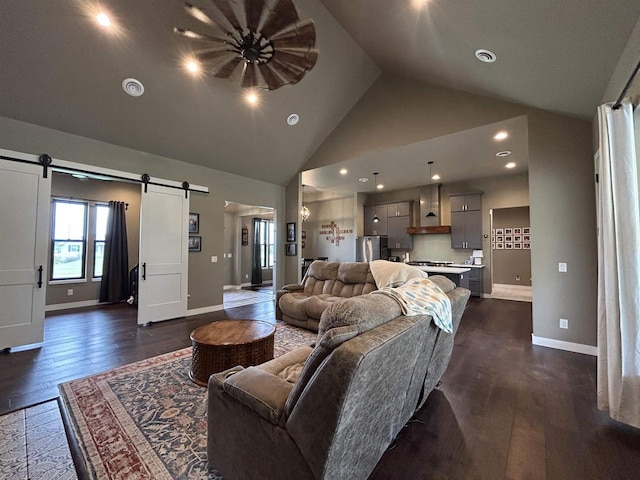 11654 Flambeau Rd, Tomah, WI 54660 - living area featuring a barn door, high vaulted ceiling, dark wood-style floors, and baseboards