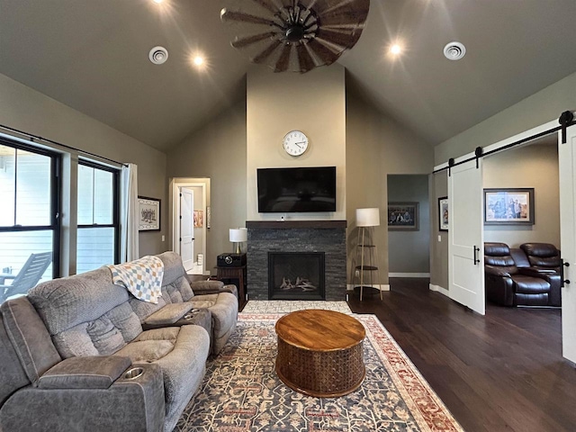 11654 Flambeau Rd, Tomah, WI 54660 - living area with a barn door, high vaulted ceiling, wood finished floors, baseboards, and a fireplace
