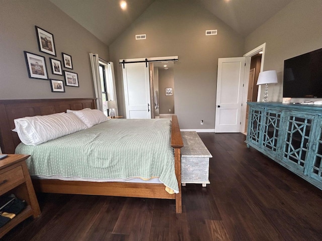 11654 Flambeau Rd, Tomah, WI 54660 - bedroom with a barn door, wood finished floors, high vaulted ceiling, and baseboards
