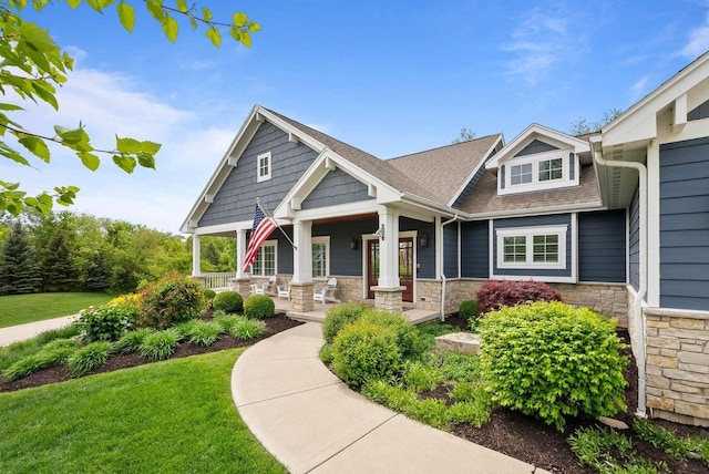 833 Red Hawk Dr, Walworth, WI 53184 - craftsman-style home featuring stone siding, covered porch, a front lawn, and a shingled roof