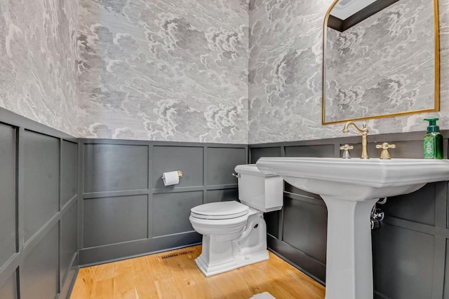 833 Red Hawk Dr, Walworth, WI 53184 - bathroom featuring a decorative wall, wood finished floors, toilet, and a wainscoted wall