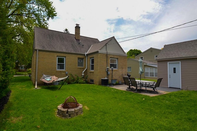 10432 W Manor Park Dr, West Allis, WI 53227 - rear view of property featuring an outdoor fire pit, brick siding, a chimney, a patio, and a yard
