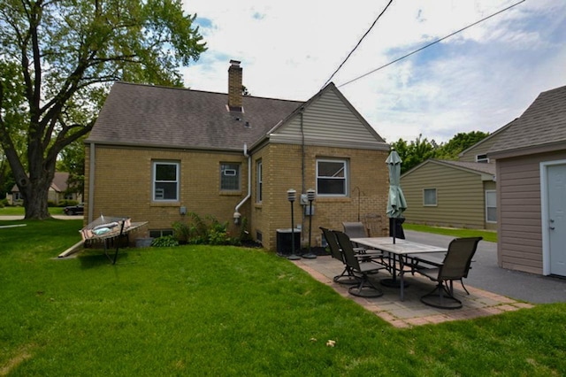 10432 W Manor Park Dr, West Allis, WI 53227 - back of property featuring brick siding, a chimney, a patio area, and a yard