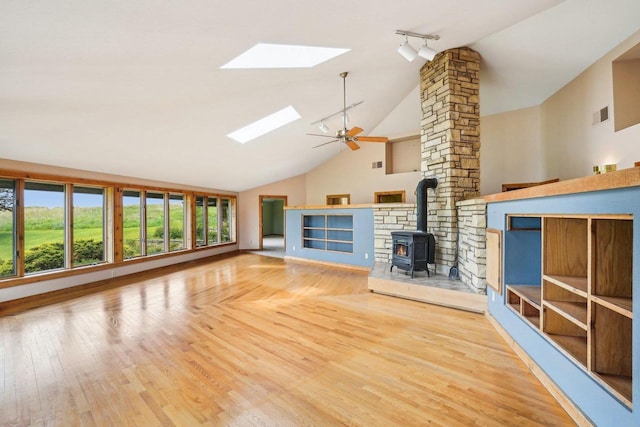 1510 County Road Qq, Mineral Point, WI 53565 - unfurnished living room featuring a skylight, a wood stove, high vaulted ceiling, wood finished floors, and ceiling fan