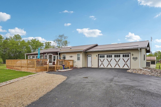 354 Pine Ct, Muscoda, WI 53573 - view of front of property featuring an attached garage, asphalt driveway, metal roof, and a deck