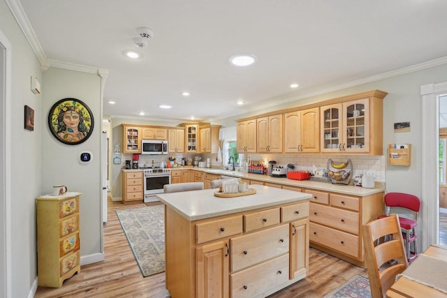 354 Pine Ct, Muscoda, WI 53573 - kitchen with white microwave, gas stove, light brown cabinets, ornamental molding, and tasteful backsplash
