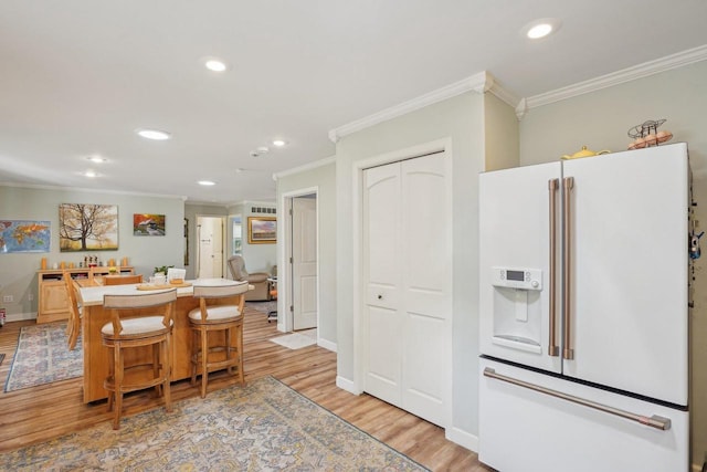 354 Pine Ct, Muscoda, WI 53573 - kitchen featuring white fridge with ice dispenser, ornamental molding, recessed lighting, light wood finished floors, and a kitchen island