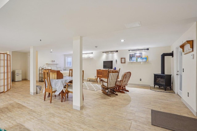 354 Pine Ct, Muscoda, WI 53573 - living room featuring a wood stove, baseboards, track lighting, and light wood-style flooring