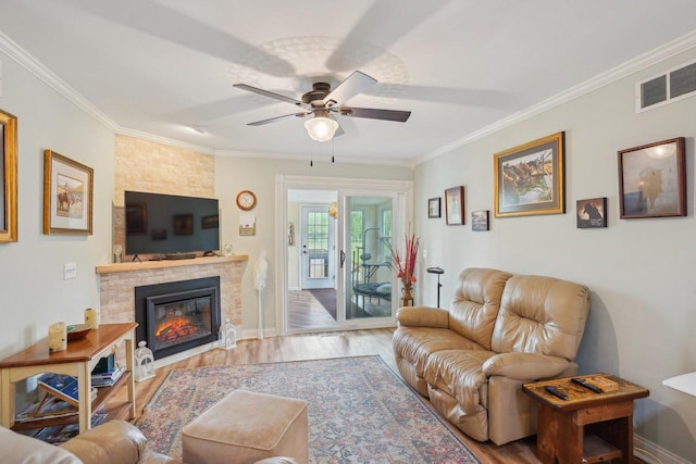 354 Pine Ct, Muscoda, WI 53573 - living room featuring crown molding, wood finished floors, ceiling fan, a fireplace, and baseboards