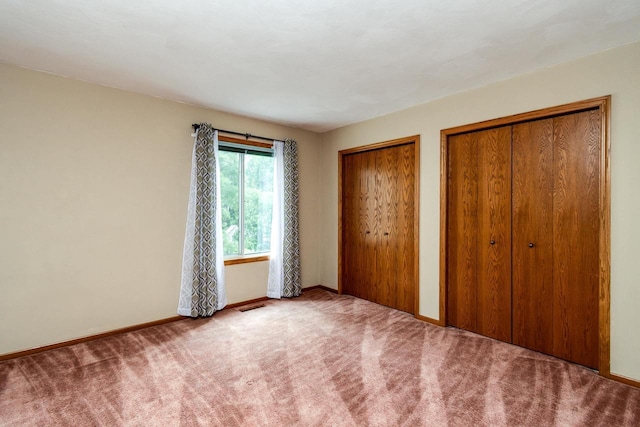 7423 Cedar Creek Trl, Madison, WI 53717 - unfurnished bedroom with two closets, carpet floors, and baseboards