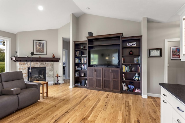 W4949 Cottage Ln, Sherwood, WI 54169 - living area featuring baseboards, lofted ceiling, light wood-style floors, and a stone fireplace