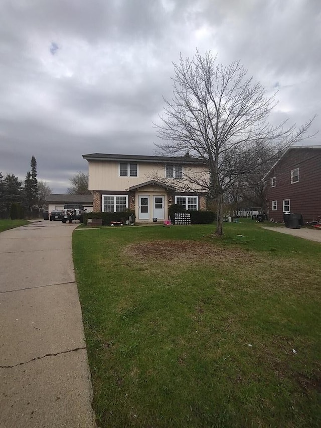 1041 Sundown Ct, Mukwonago, WI 53149 - traditional home featuring a front yard, concrete driveway, and brick siding