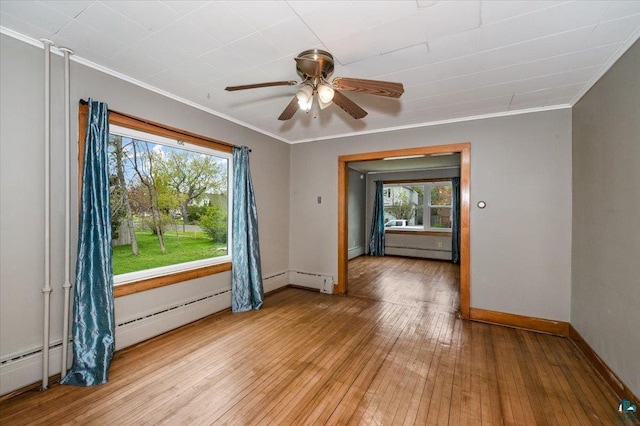 1112 Baxter Ave, Superior, WI 54880 - empty room with ornamental molding, a ceiling fan, healthy amount of natural light, a baseboard heating unit, and light wood-type flooring