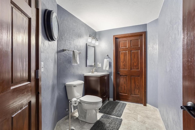 W5841 Easter Lily Dr, Appleton, WI 54915 - bathroom with a textured wall, toilet, vanity, and baseboards
