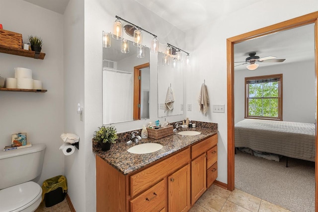 665 N Prairie Rd, Fond Du Lac, WI 54935 - ensuite bathroom with double vanity, toilet, tile patterned floors, ceiling fan, and baseboards