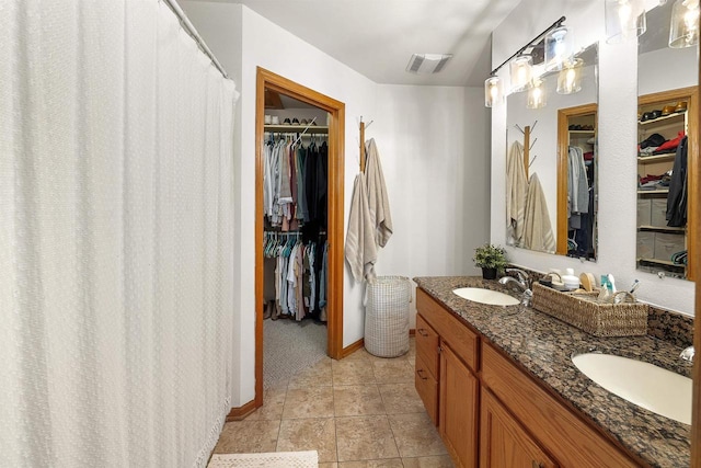 665 N Prairie Rd, Fond Du Lac, WI 54935 - bathroom with double vanity, a spacious closet, tile patterned floors, and baseboards