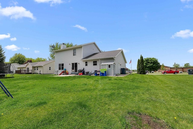 665 N Prairie Rd, Fond Du Lac, WI 54935 - back of property with a trampoline, a chimney, and a yard