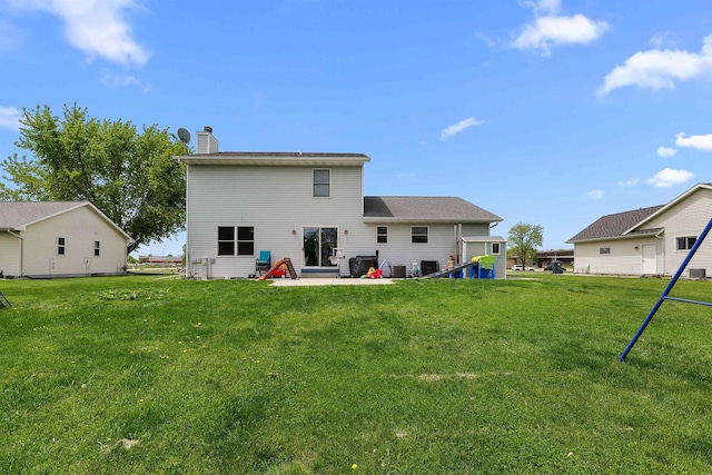 665 N Prairie Rd, Fond Du Lac, WI 54935 - rear view of property featuring a chimney, a lawn, and a patio area