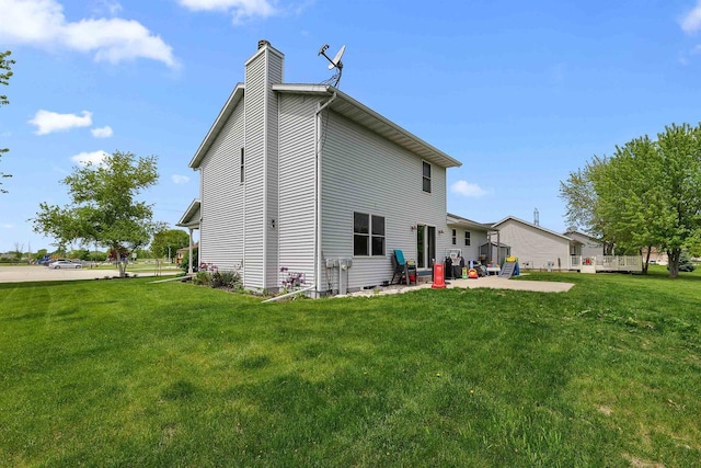 665 N Prairie Rd, Fond Du Lac, WI 54935 - back of property with a chimney, a patio area, and a yard