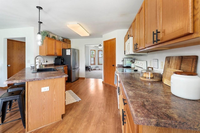 665 N Prairie Rd, Fond Du Lac, WI 54935 - kitchen with a sink, freestanding refrigerator, a peninsula, a breakfast bar area, and dark countertops