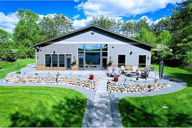 N528 Park Dr, New Auburn, WI 54757 - rear view of property with a fire pit, a patio, a lawn, and stone siding