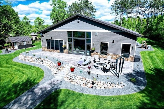 N528 Park Dr, New Auburn, WI 54757 - back of house with a patio, a fire pit, stone siding, and an outbuilding