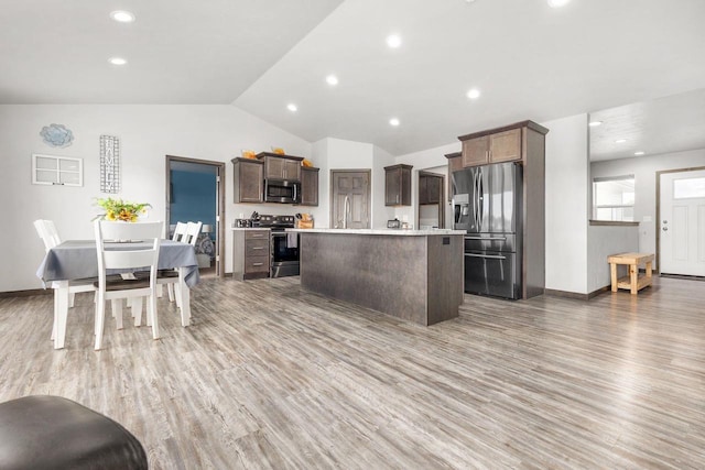 1732 Patriot Way, Neenah, WI 54956 - kitchen featuring stainless steel appliances, light countertops, wood finished floors, vaulted ceiling, and a center island