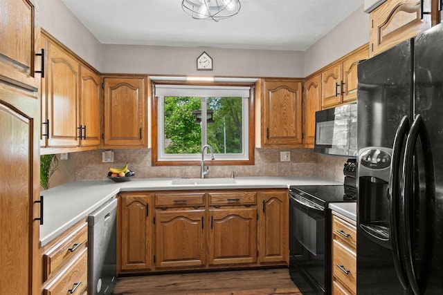1651 4th St, Port Edwards, WI 54469 - kitchen with black appliances, a sink, light countertops, brown cabinetry, and tasteful backsplash