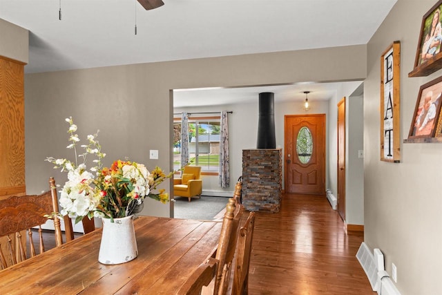 1651 4th St, Port Edwards, WI 54469 - dining space featuring hardwood / wood-style floors, baseboards, a wood stove, and baseboard heating