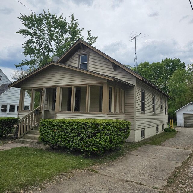 1048 W Wisconsin St, Portage, WI 53901 - bungalow-style home featuring a garage, an outbuilding, and driveway
