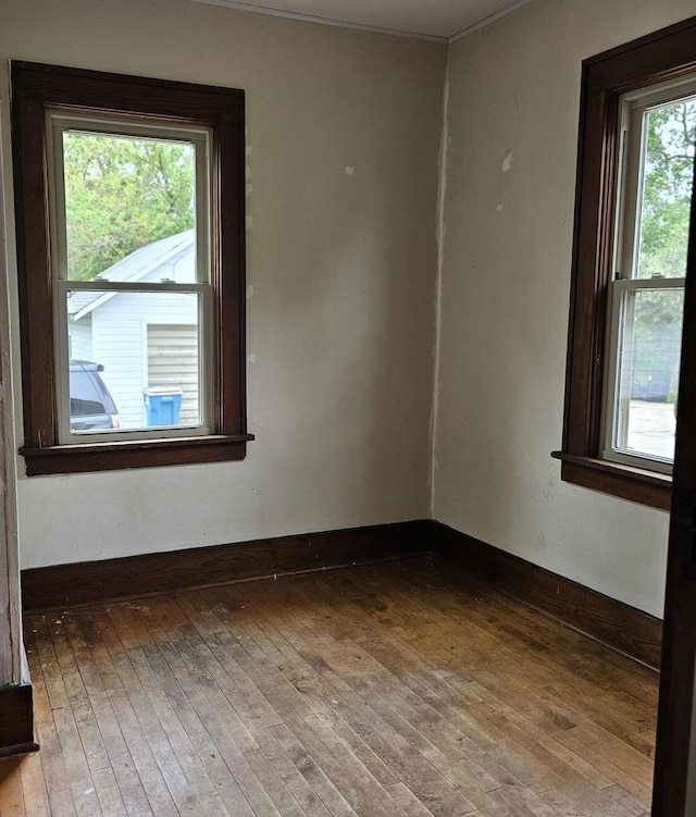 1048 W Wisconsin St, Portage, WI 53901 - empty room featuring hardwood / wood-style flooring, baseboards, and ornamental molding