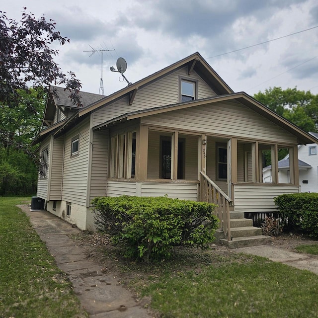 1048 W Wisconsin St, Portage, WI 53901 - bungalow with a porch, cooling unit, and a front lawn