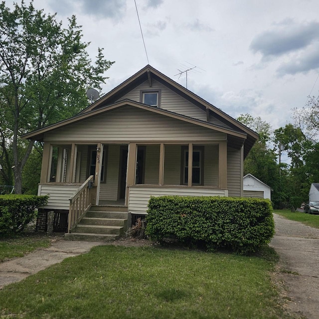1048 W Wisconsin St, Portage, WI 53901 - bungalow-style home featuring covered porch, a front lawn, and a detached garage