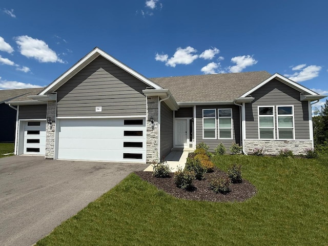 941 Colt Dr, Belleville, WI 53508 - view of front facade featuring stone siding, driveway, an attached garage, a front yard, and a shingled roof