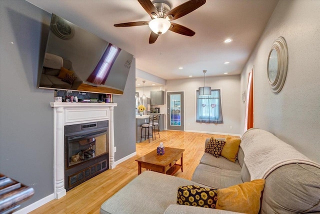 614 Dewitt St, Portage, WI 53901 - living room with a glass covered fireplace, light wood-type flooring, a ceiling fan, baseboards, and recessed lighting