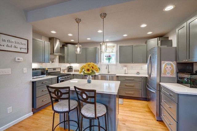 614 Dewitt St, Portage, WI 53901 - kitchen with wall chimney range hood, stainless steel appliances, a sink, a kitchen bar, and backsplash
