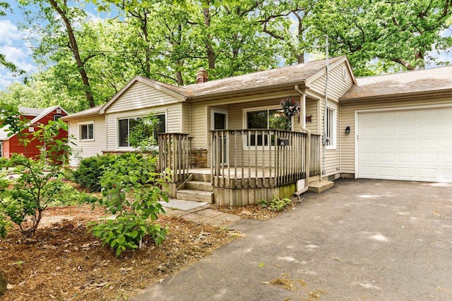 4705 Winnequah Rd, Monona, WI 53716 - ranch-style house with asphalt driveway, an attached garage, covered porch, and a chimney